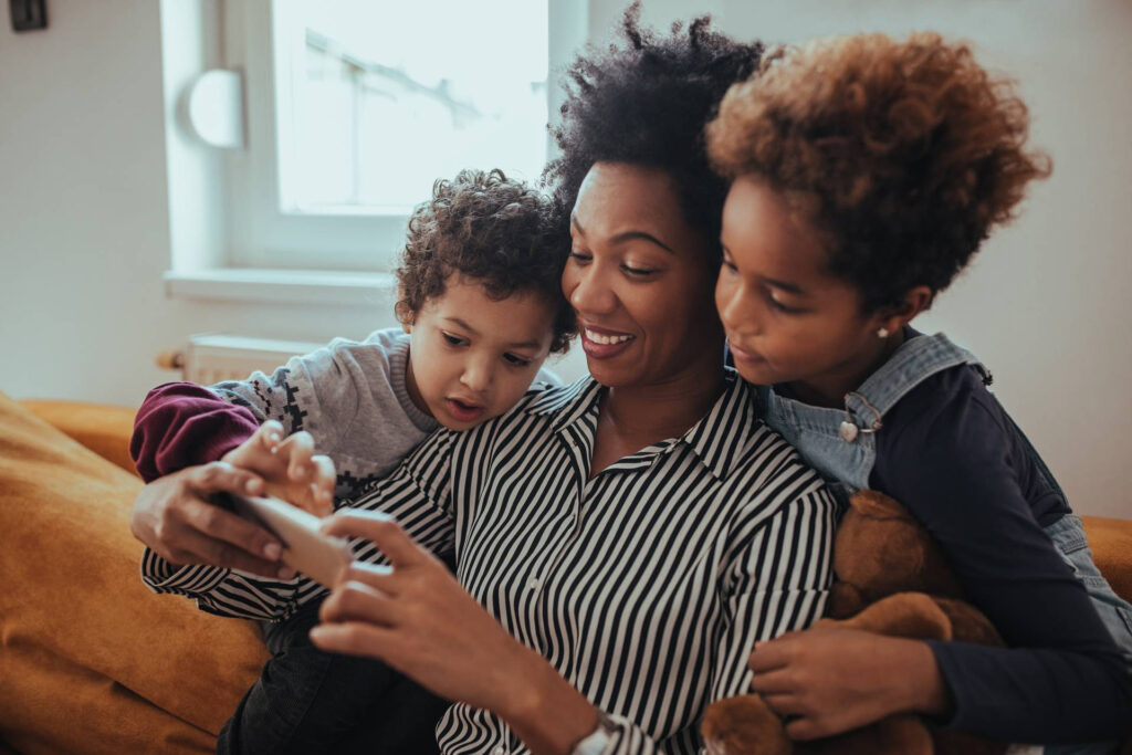 Mom with two kids watching mobile screen